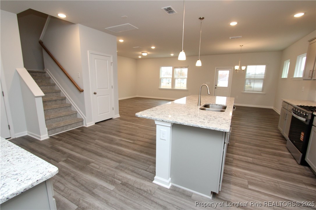 461 Grange Farm Place Raleigh, NC 27603 - Photo 7 of 50 a open kitchen with kitchen island a sink appliances and a living room
