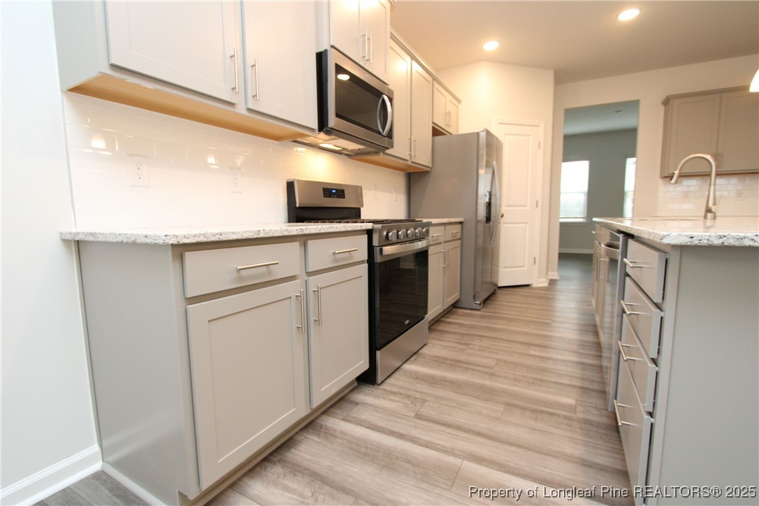 461 Grange Farm Place Raleigh, NC 27603 - Photo 9 of 50 a kitchen with stainless steel appliances granite countertop a refrigerator a stove and a sink