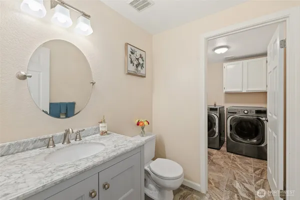 a bathroom with a granite countertop sink a mirror and toilet