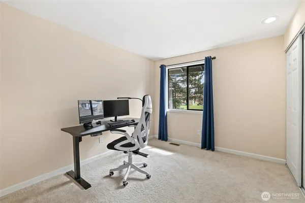 a view of a workspace with furniture and a window