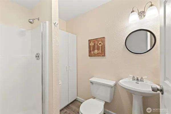a bathroom with a toilet a sink and mirror