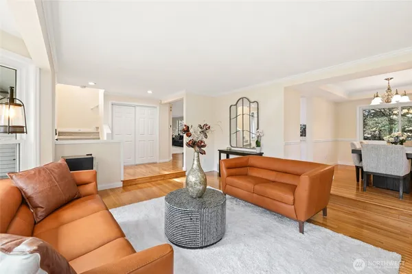 a living room with furniture kitchen view and a large window