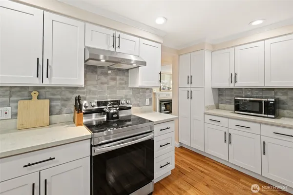 a kitchen with stainless steel appliances granite countertop a stove a sink and a refrigerator