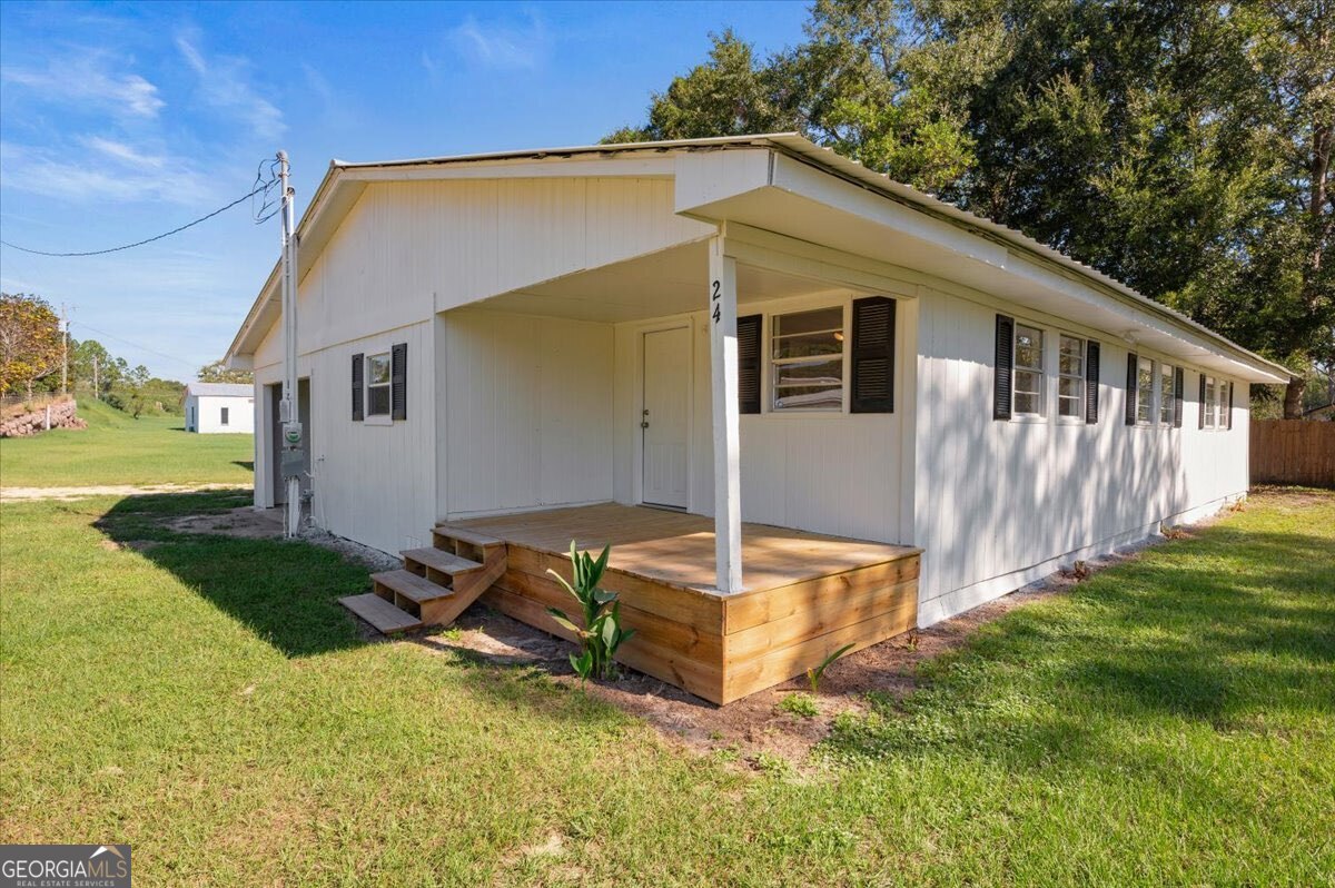 24 Sangster Road Jesup, GA 31545 - Photo 1 of 35 a front view of house with yard and trees in the background