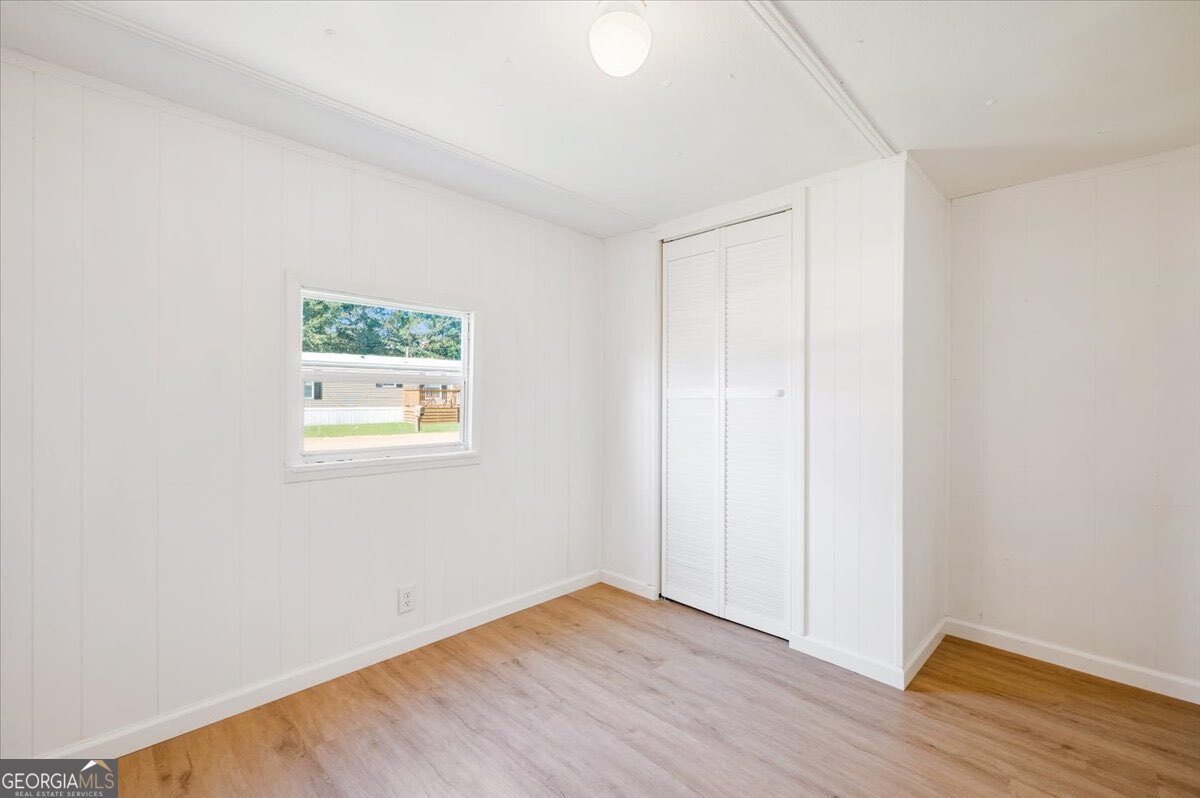24 Sangster Road Jesup, GA 31545 - Photo 11 of 35 an empty room with wooden floor and windows