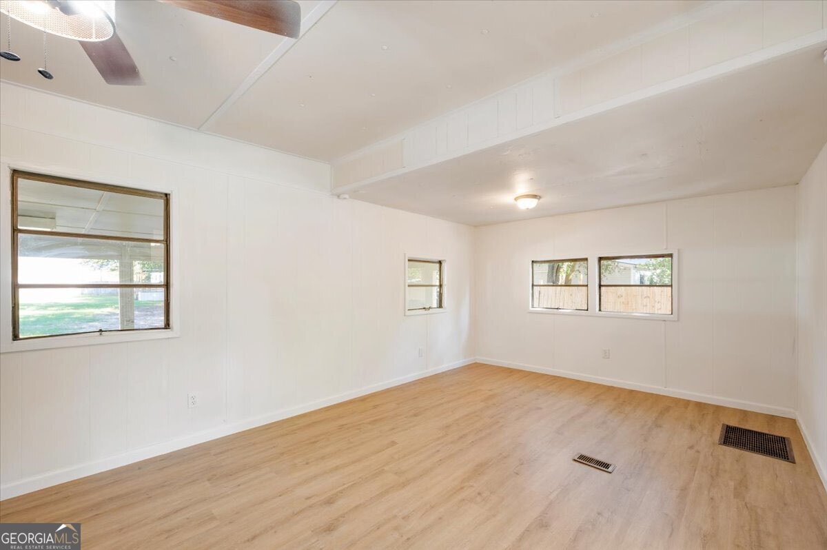 24 Sangster Road Jesup, GA 31545 - Photo 22 of 35 wooden floor in an empty room with a window