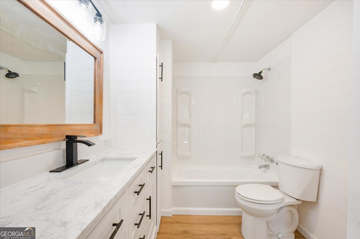 24 Sangster Road Jesup, GA 31545 - Photo 5 of 35 a bathroom with a granite countertop toilet sink and a bathtub
