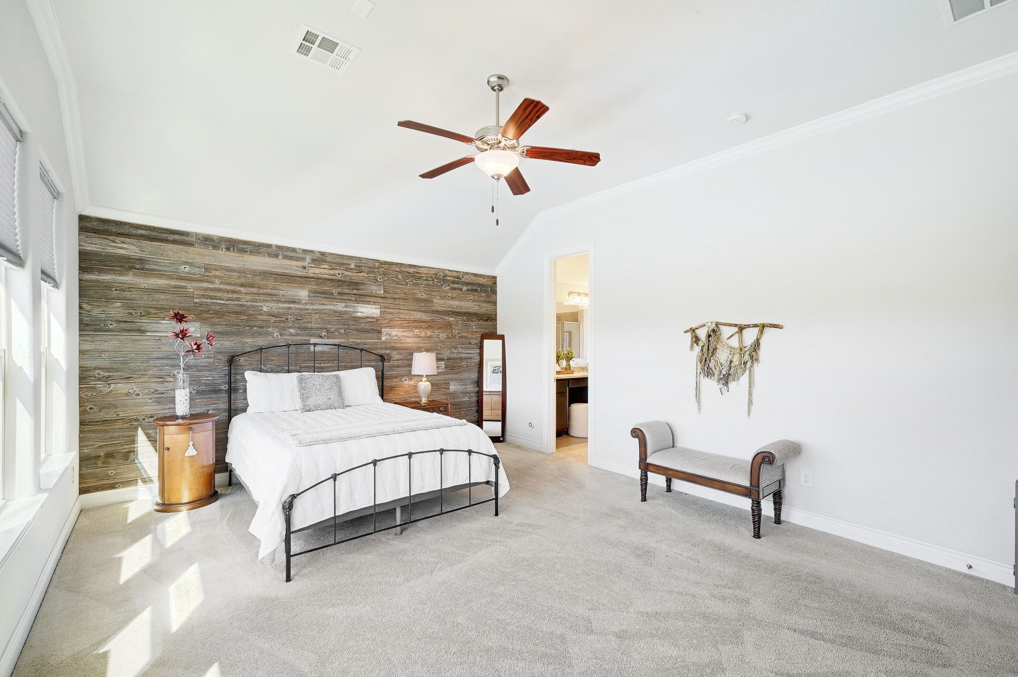 960 Blue Ridge Drive Dripping Springs, TX 78620 - Photo 13 of 38 The spacious primary bedroom features an accent wall, ceiling fan, lofted ceiling, and crown molding