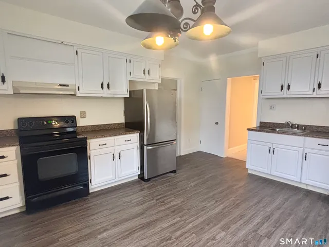a kitchen with a refrigerator and white cabinets