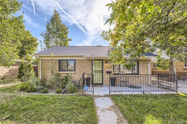 a view of a house with a small yard and wooden fence