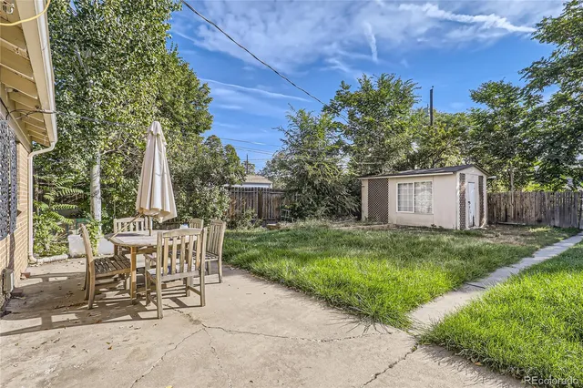 a view of a chairs and table in backyard