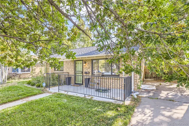a view of a house with a wooden deck and a big yard