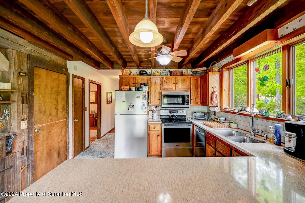 33 Hobbs Road Tunkhannock, PA 18657 - Photo 21 of 83 a large kitchen with stainless steel appliances granite countertop a stove a sink a refrigerator and a granite countertops with cabinets next to a window