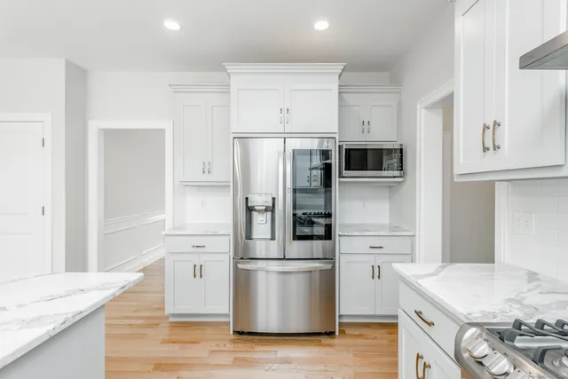 a kitchen with a refrigerator stove and wooden cabinets