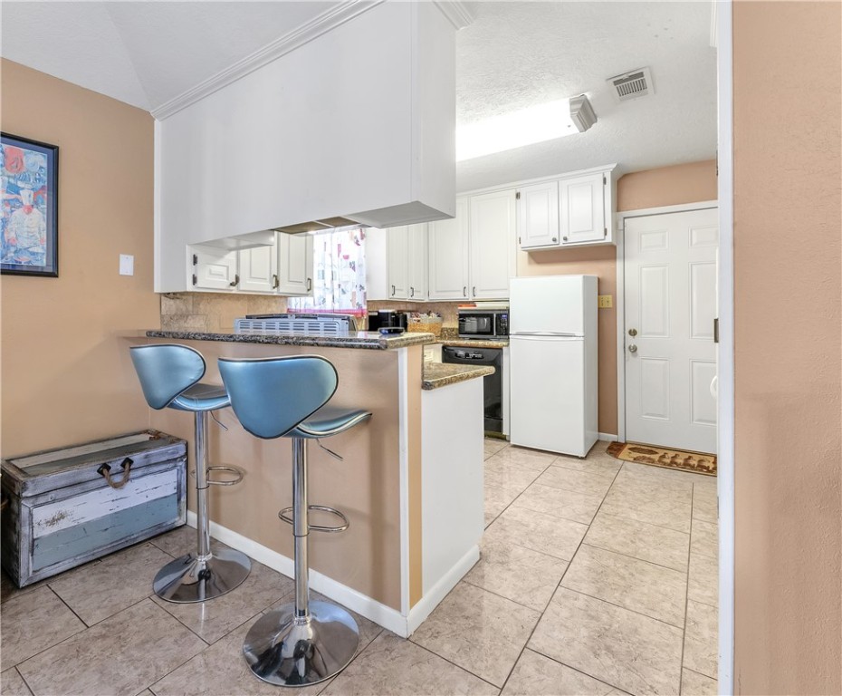 3319 Big Bend Drive Bryan, TX 77803 - Photo 15 of 19 a kitchen with granite countertop a stove a refrigerator and white cabinets