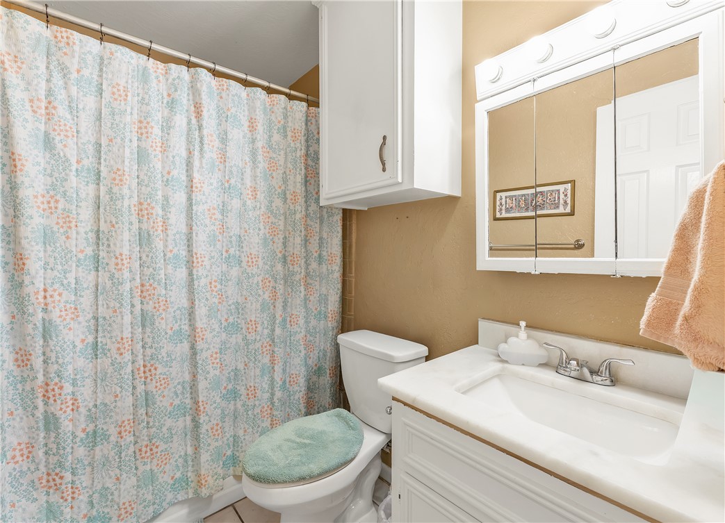 3319 Big Bend Drive Bryan, TX 77803 - Photo 17 of 19 a bathroom with a granite countertop sink and a toilet