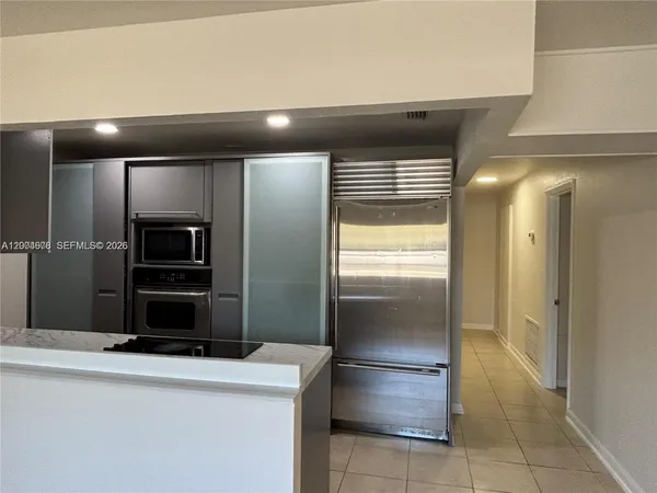 a kitchen with a refrigerator and a stove top oven