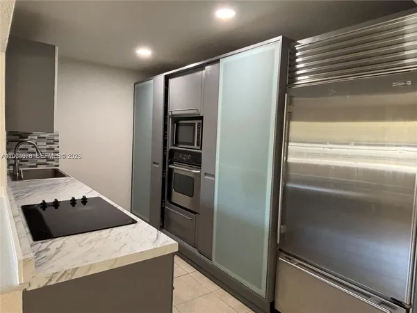 a kitchen with stainless steel appliances kitchen island a refrigerator and a stove top oven