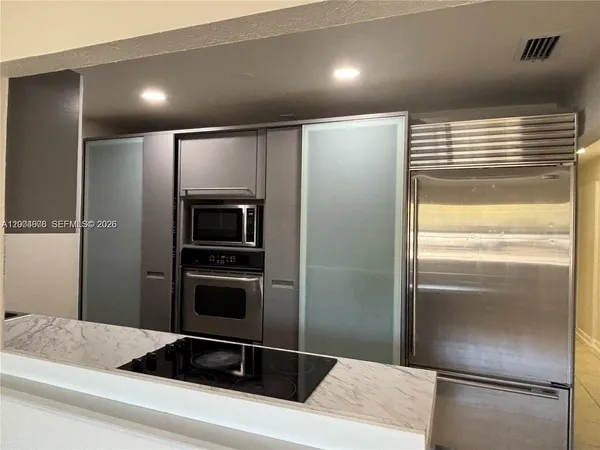 a kitchen with a refrigerator and microwave