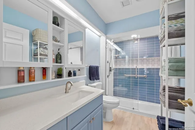 a bathroom with a sink a toilet and shower