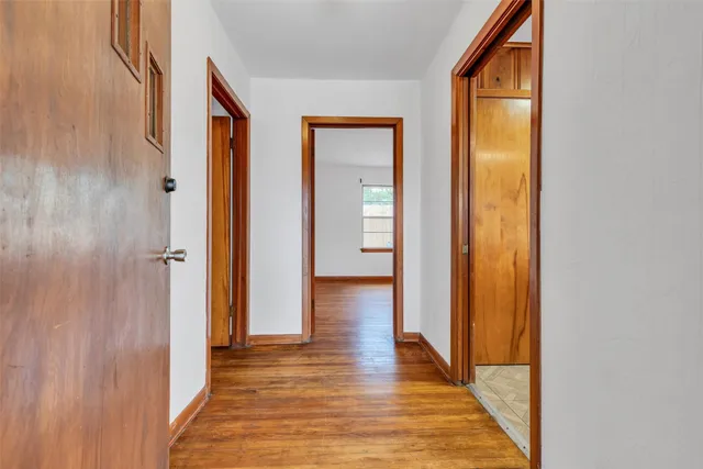 a view of a hallway with wooden floor and closet