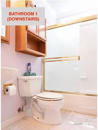 a white toilet sitting next to a bathroom sink and a shower