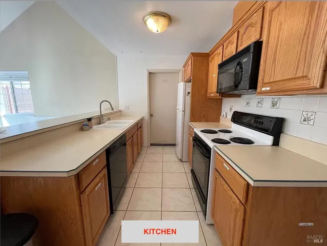 a kitchen with a sink a stove top oven and cabinets