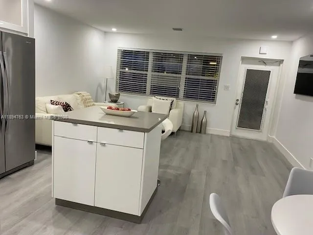 a view of kitchen with stainless steel appliances dining table and chairs