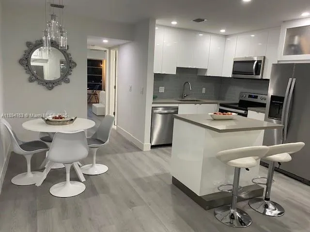 a kitchen with a dining table chairs and microwave