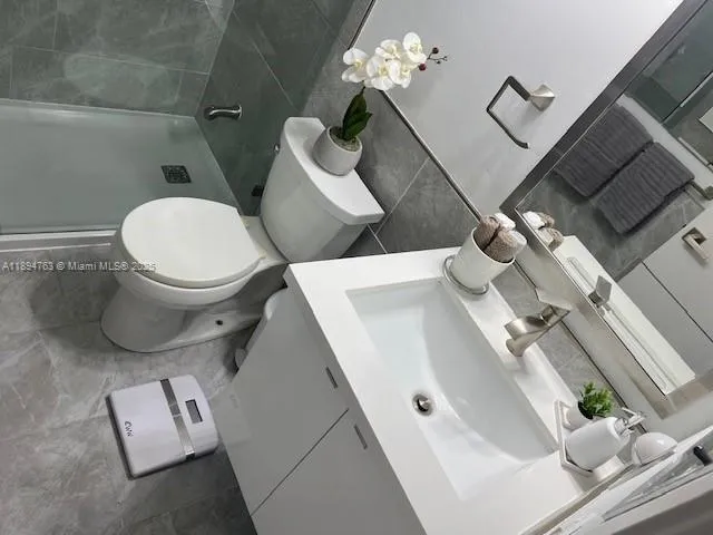 a white toilet sitting next to a bathroom sink