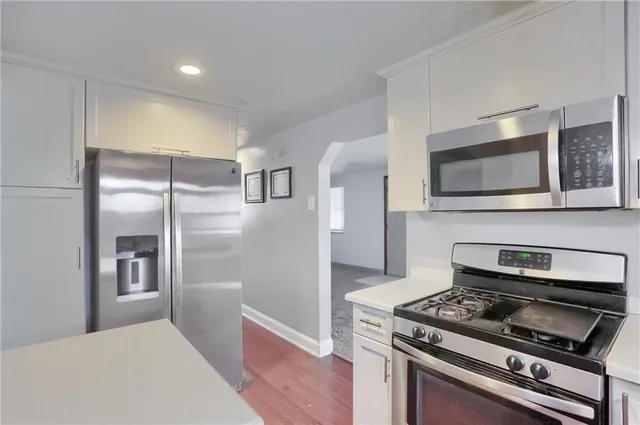 a kitchen with stainless steel appliances a stove a microwave and a refrigerator