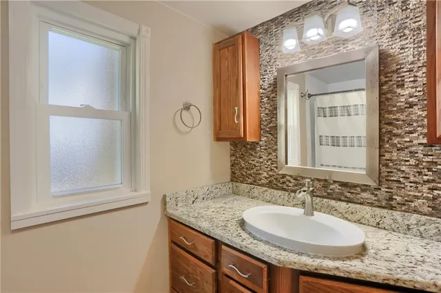 a bathroom with a granite countertop sink and a mirror