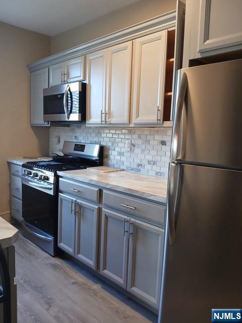70 Main Street, Unit 3 Little Falls, NJ 07424 - Photo 10 of 10 a kitchen with stainless steel appliances granite countertop a refrigerator stove and microwave