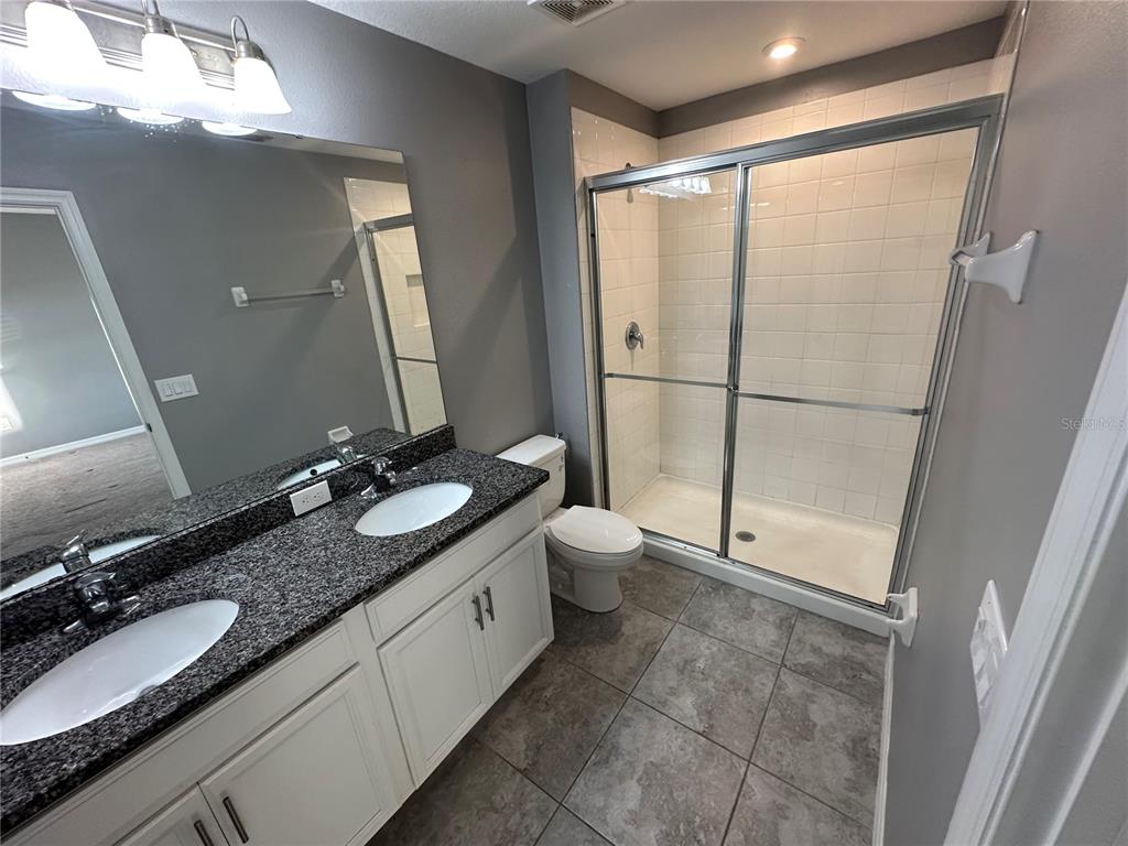 10834 Wyne Tree Orlando, FL 32824 - Photo 13 of 33 a bathroom with a granite countertop sink toilet and mirror