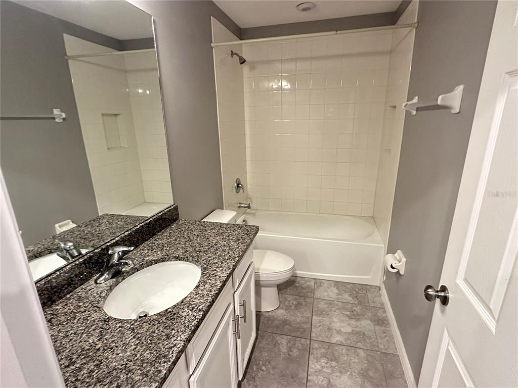 10834 Wyne Tree Orlando, FL 32824 - Photo 21 of 33 a bathroom with a granite countertop sink toilet a mirror and shower