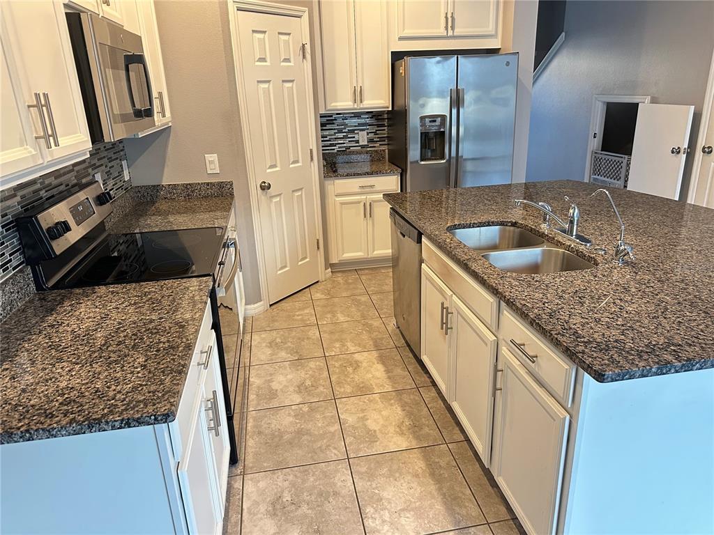 10834 Wyne Tree Orlando, FL 32824 - Photo 6 of 33 a kitchen with stainless steel appliances granite countertop a sink stove and refrigerator