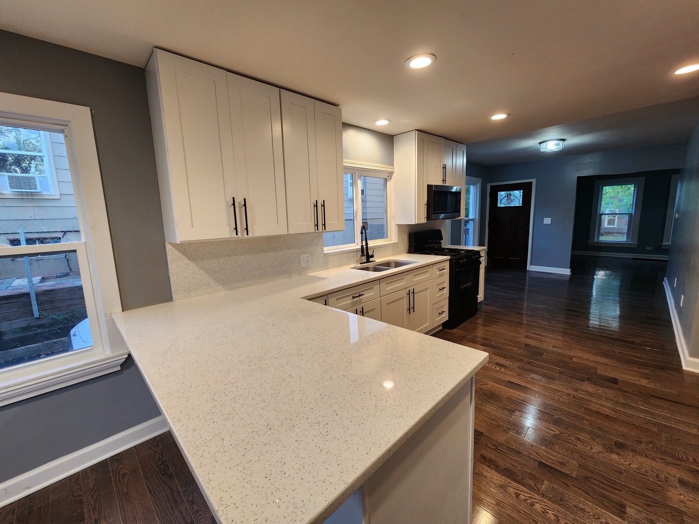 62 Seneca Street Elgin, IL 60120 - Photo 7 of 20 a large white kitchen with wooden floor and stainless steel appliances