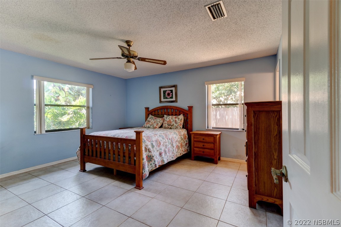 2628 Queen Palm Drive Edgewater, FL 32141 - Photo 12 of 15 a bedroom with a bed and a chandelier