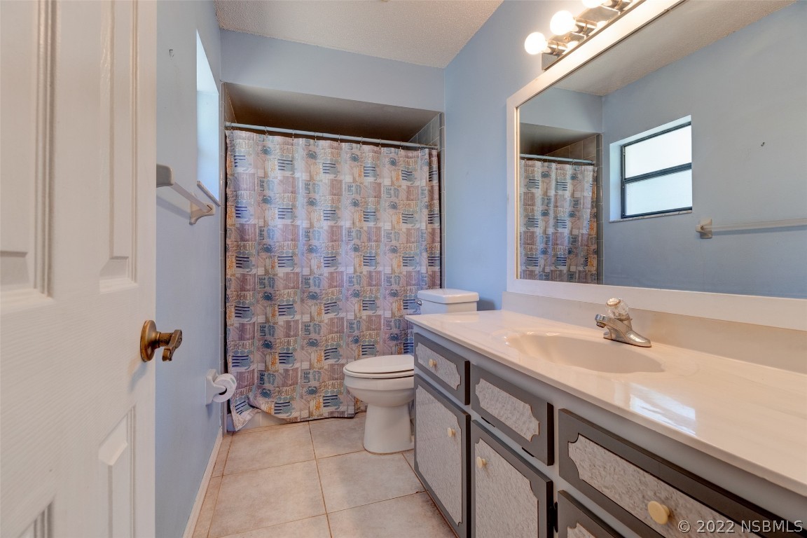 2628 Queen Palm Drive Edgewater, FL 32141 - Photo 13 of 15 a bathroom with a sink a toilet a mirror and shower