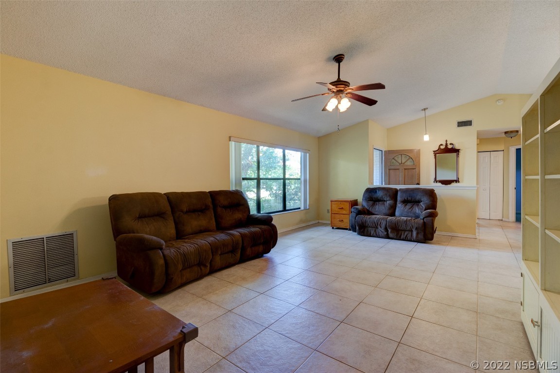 2628 Queen Palm Drive Edgewater, FL 32141 - Photo 3 of 15 a living room with furniture a ceiling fan and a window