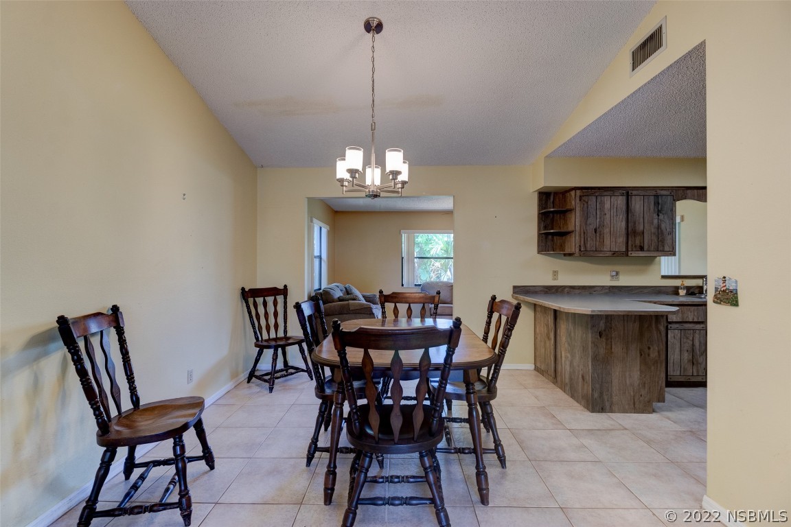 2628 Queen Palm Drive Edgewater, FL 32141 - Photo 6 of 15 a view of a dining room with furniture and chandelier
