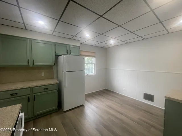 a view of kitchen with refrigerator and wooden floor