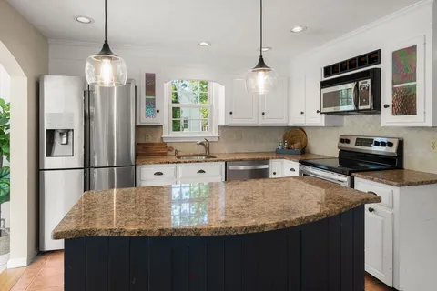 a kitchen with stainless steel appliances granite countertop a sink refrigerator and microwave