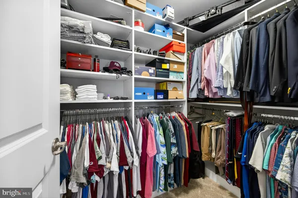 a view of walk in closet with clothes and shoes