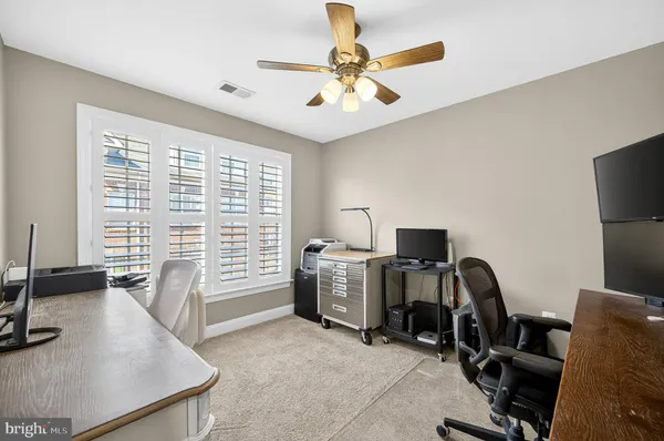 a view of a workspace with furniture and a window