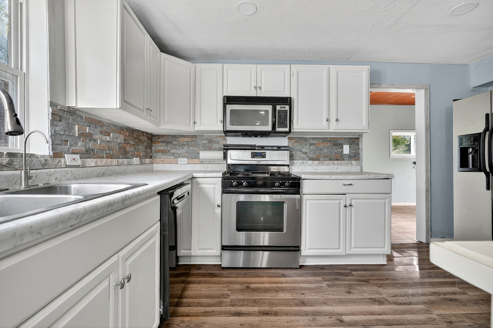 26427 West Prospect Avenue Antioch, IL 60002 - Photo 6 of 22 a kitchen with stainless steel appliances granite countertop a stove a sink and a microwave