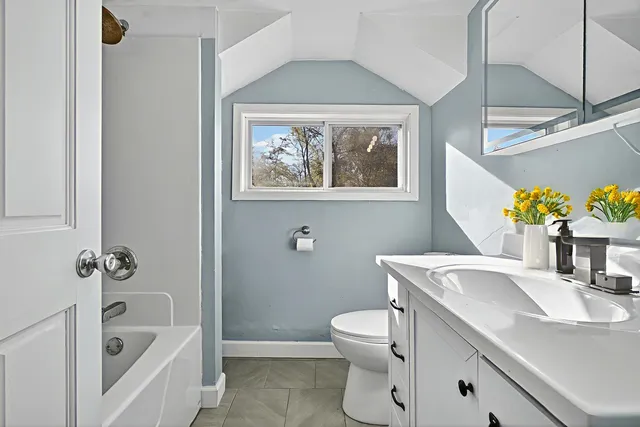 a bathroom with a sink mirror vanity and toilet