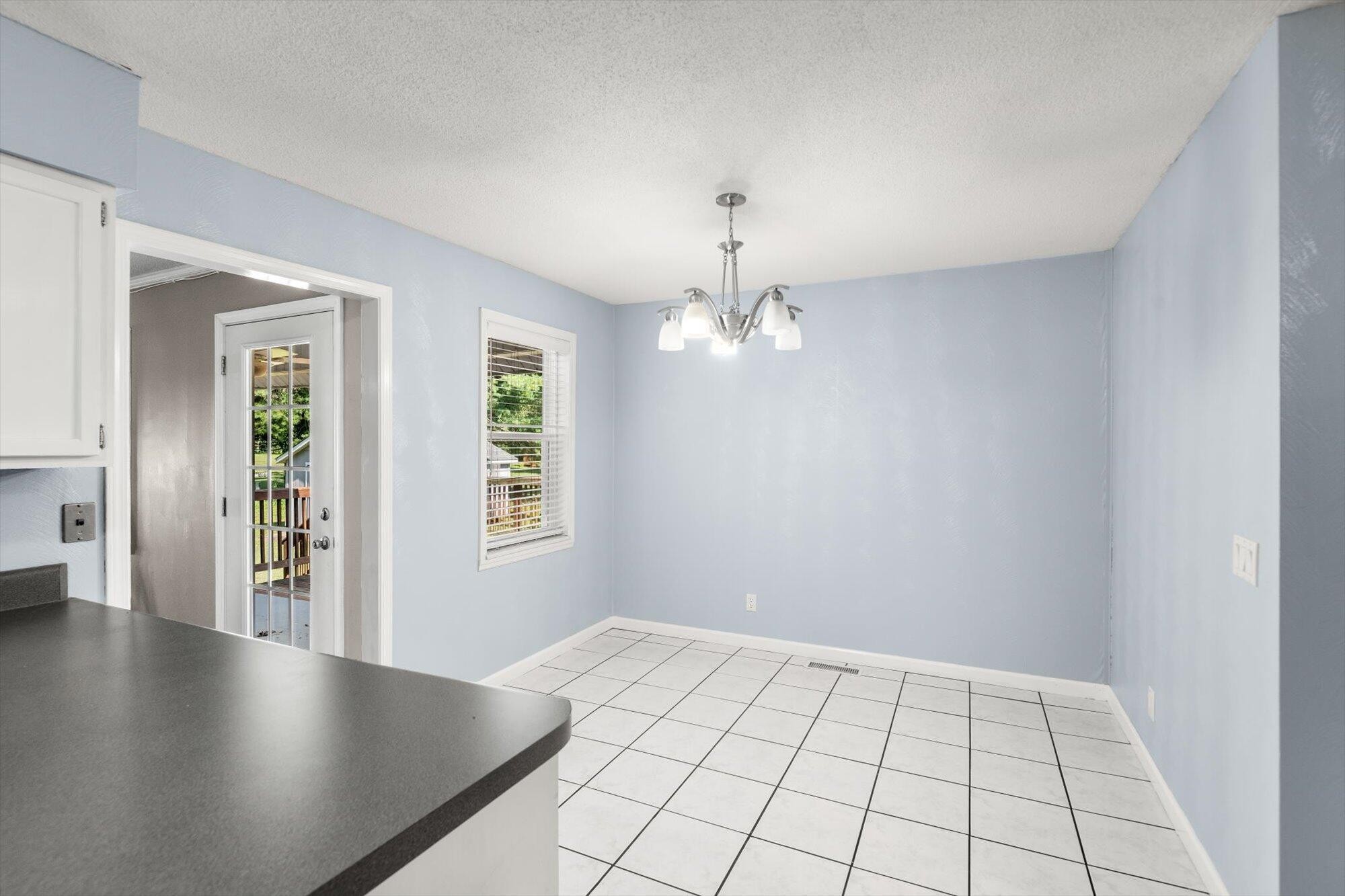 1302 Ridgeway Circle Athens, TN 37303 - Photo 9 of 17 an empty room with chandelier fan and windows