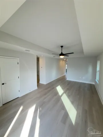 an empty room with a ceiling fan and carpet
