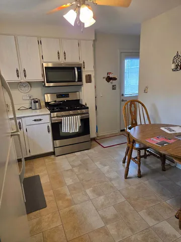 a kitchen with granite countertop a stove a sink and a microwave